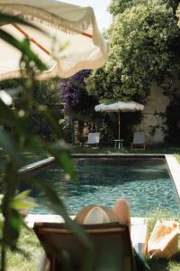 a person laying in a chair next to a swimming pool at Maison Jullian in Béziers