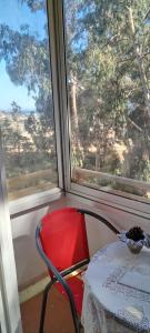 una sedia rossa seduta davanti a una finestra di Departamento en Condominio Bosques de El Tabo a El Tabo
