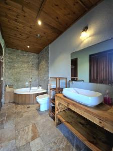 y baño grande con bañera, lavamanos y bañera. en Villa Gshur, en Eli Ad