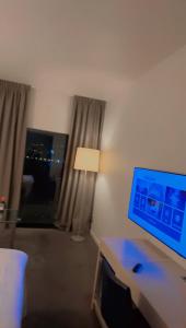 Un escritorio con un monitor de computadora y una lámpara en una habitación. en Nice guest apartment within walking distance to Kalmar central station, en Kalmar 2 fotos más