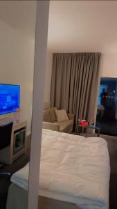 Un dormitorio con una cama, un sofá y un televisor. en Nice guest apartment within walking distance to Kalmar central station, en Kalmar