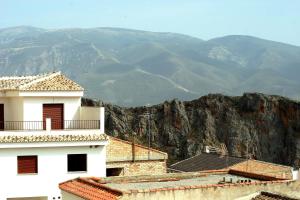 a white building with mountains in the background at Hotel Lanjaron in Lanjarón