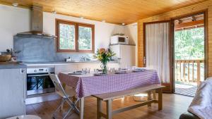 Una cocina con una mesa con un jarrón de flores encima. en Chalet lumineux et spacieux entre Risoul Vars et les stations du Queyras, en Guillestre 56 fotos más