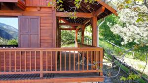 un porche de madera de una cabaña con puerta en Chalet lumineux et spacieux entre Risoul Vars et les stations du Queyras, en Guillestre