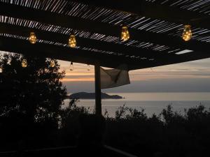 a view of the ocean from a patio with lights at Notre paradis in Lumio