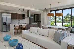 un soggiorno con un divano bianco e una cucina di Donoma Las Terrenas Beach Hotel & Spa, Autograph Collection a Las Terrenas