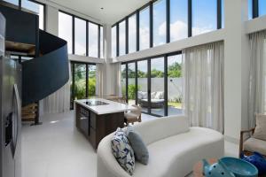un soggiorno con divano bianco e alcune finestre di Donoma Las Terrenas Beach Hotel & Spa, Autograph Collection a Las Terrenas