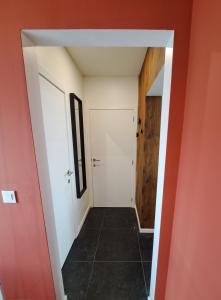 a hallway with a white door and a tile floor at L'Escapade Tournaisienne in Tournai