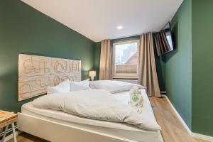 a bedroom with a bed with green walls and a window at Hotel Seepferdchen Zimmer 6 Eckernförde Self-Check-In in Eckernförde
