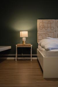 Un dormitorio con una cama y una mesa con una lámpara. en Hotel Seepferdchen Zimmer 6 Eckernförde Self-Check-In, en Eckernförde