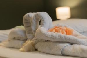 Una pila de toallas y un juguete en una cama en Hotel Seepferdchen Zimmer 6 Eckernförde Self-Check-In, en Eckernförde