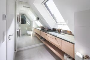 a bathroom with a sink and a skylight at Strandhaus Südwesthörn in Norderney +71 photos