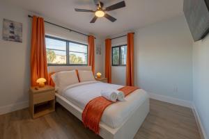 Schlafzimmer mit einem großen Bett und orangefarbenen Vorhängen in der Unterkunft Three Tides Apartments in Clearwater Beach + 34 Fotos