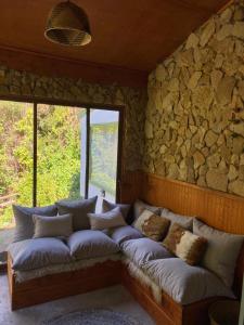 eine Couch in einem Raum mit einer Steinwand in der Unterkunft Alojamiento el Arrayán in Temuco