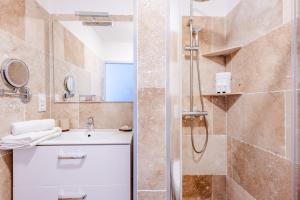 um banheiro com pia e chuveiro em Maison des Croisades em Aigues-Mortes