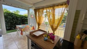 een keuken met een balkon met een tafel en een raam bij Brin d'ile Anse des Rochers vue mer à 50 m de la plage et piscine in Saint-François