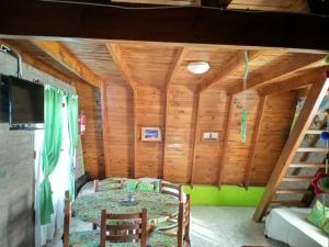 a dining room with a table in a room with wooden walls at Cabañas Terra Natura in Bialet Massé