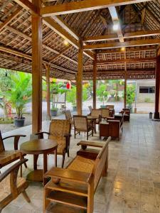 Sokkyo Homestay Kaliurang في Ngemplak: فناء مغطى بالطاولات والكراسي والطاولات