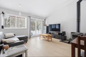 a living room with a couch and a table at The refuge of the slopes, ski in, ski out in Stoneham