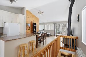 a kitchen and living room with a counter and stools at The refuge of the slopes, ski in, ski out in Stoneham +18 photos