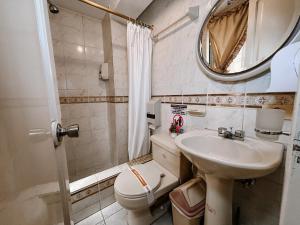 ein Badezimmer mit Waschbecken, Toilette und Spiegel in der Unterkunft Hotel Señorial in Ambato