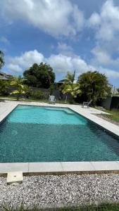 a swimming pool with blue water in a yard at T3 moderne avec piscine proche de Family Plaza in Matoury