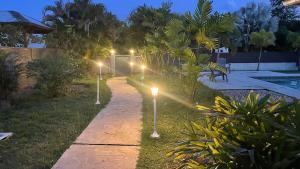 a pathway with lights in a yard at night at T3 moderne avec piscine proche de Family Plaza in Matoury
