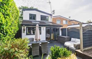 um pátio com um sofá e um guarda-chuva em Hot Tub and Garden Spacious Unique 3 Bed House em Allesley