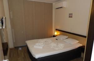 奥布佐尔Апартамент Б003 в Обзор Бийч Резорт- море пред прозореца, плаж пред вратата !!!的卧室里有一张白色的床，床上放着毛巾 更多23张照片