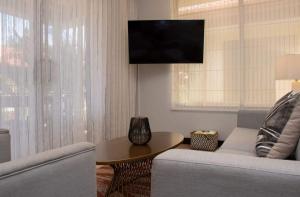 Μια τηλεόραση ή/και κέντρο ψυχαγωγίας στο 2BD Family Escape Gated AC Terrace Pools