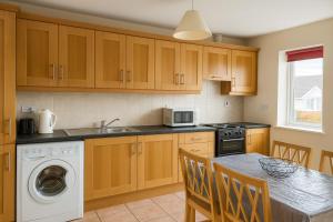 cocina con lavadora y mesa con sillas en Apartment in Russet Court, Free Wi-fi and Parking, en Cork 4 fotos más