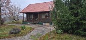 eine kleine Holzhütte mit rotem Dach in der Unterkunft На схилах річки Рось in Bila Zerkwa