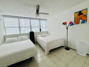 une chambre avec deux lits et une fenêtre dans l'établissement Hobie Beachfront Apartment Isla Verde, à San Juan 66 autres photos