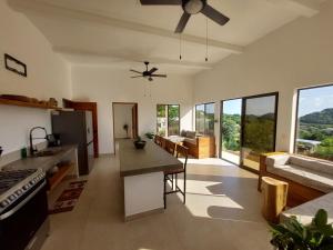 una cucina e un soggiorno con ventilatore a soffitto di Villa BotaNICA guest house a San Juan del Sur