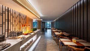 a row of tables and chairs in a restaurant at Holiday Inn Express Guangzhou Baiyun Airport T2 by IHG in Huadu