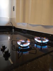 a stove top oven with several fires on it at Morada 1 do Jardim do Éden in Parnaíba +5 photos