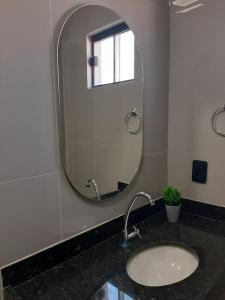 a bathroom with a sink and a mirror at Morada 1 do Jardim do Éden in Parnaíba