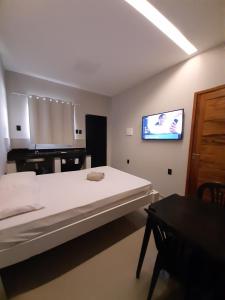 a bedroom with a large bed with a tv on the wall at Morada 1 do Jardim do Éden in Parnaíba