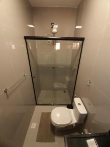 a bathroom with a white toilet and a shower at Morada 1 do Jardim do Éden in Parnaíba