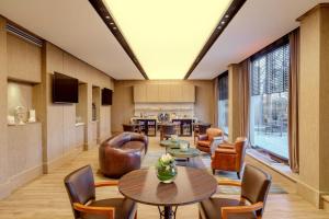 a hotel lobby with tables and chairs at Marriott Hotel Buenos Aires Ezeiza Airport in Ezeiza