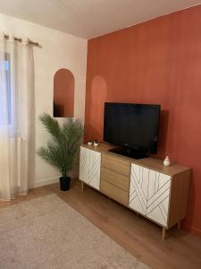 un soggiorno con una TV a schermo piatto su un mobile di Cocon de douceur a La Ravoire