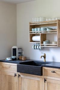 Lo-Reningeにあるde Hooibloemのキッチン(黒いカウンタートップ、シンク付)