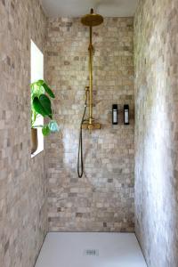 Lo-Reningeにあるde Hooibloemのレンガの壁のバスルーム(シャワー付)