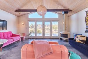 een woonkamer met roze meubels en een open haard bij The Giddyup in Pioneertown