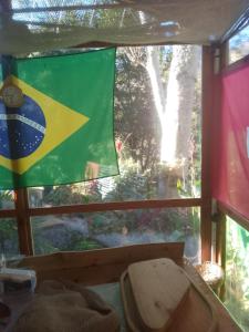 eine Flagge, die in einem Fenster eines Zimmers hängt in der Unterkunft Casa Surpresa Europäisches Flair in São José dos Campos