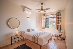 een slaapkamer met een bed, een spiegel en een stoel bij Pacífico Surf in Brisas de Zicatela