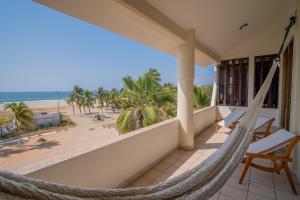 een hangmat op een balkon met uitzicht op het strand bij Pacífico Surf in Brisas de Zicatela