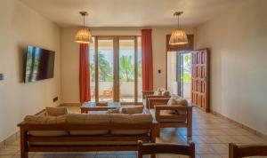 een woonkamer met een bank en twee stoelen bij Pacífico Surf in Brisas de Zicatela
