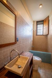 een badkamer met een wastafel, een toilet en een bad bij Pacífico Surf in Brisas de Zicatela