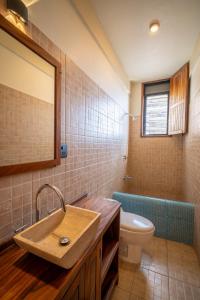 een badkamer met een wastafel, een toilet en een spiegel bij Pacífico Surf in Brisas de Zicatela +17 foto's